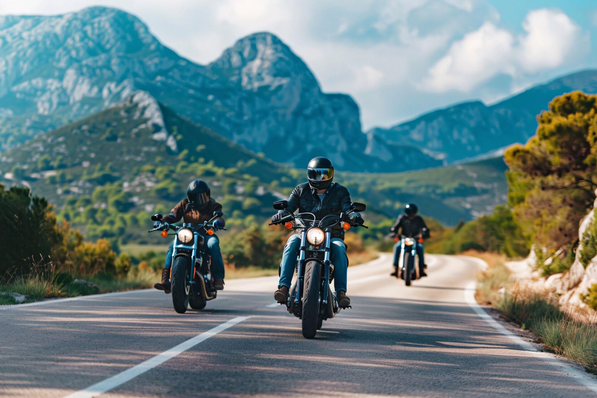 Three bikers ride their motorcycles on a winding road.